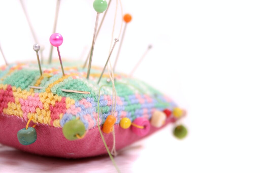 Pink Pincushion with pins in it